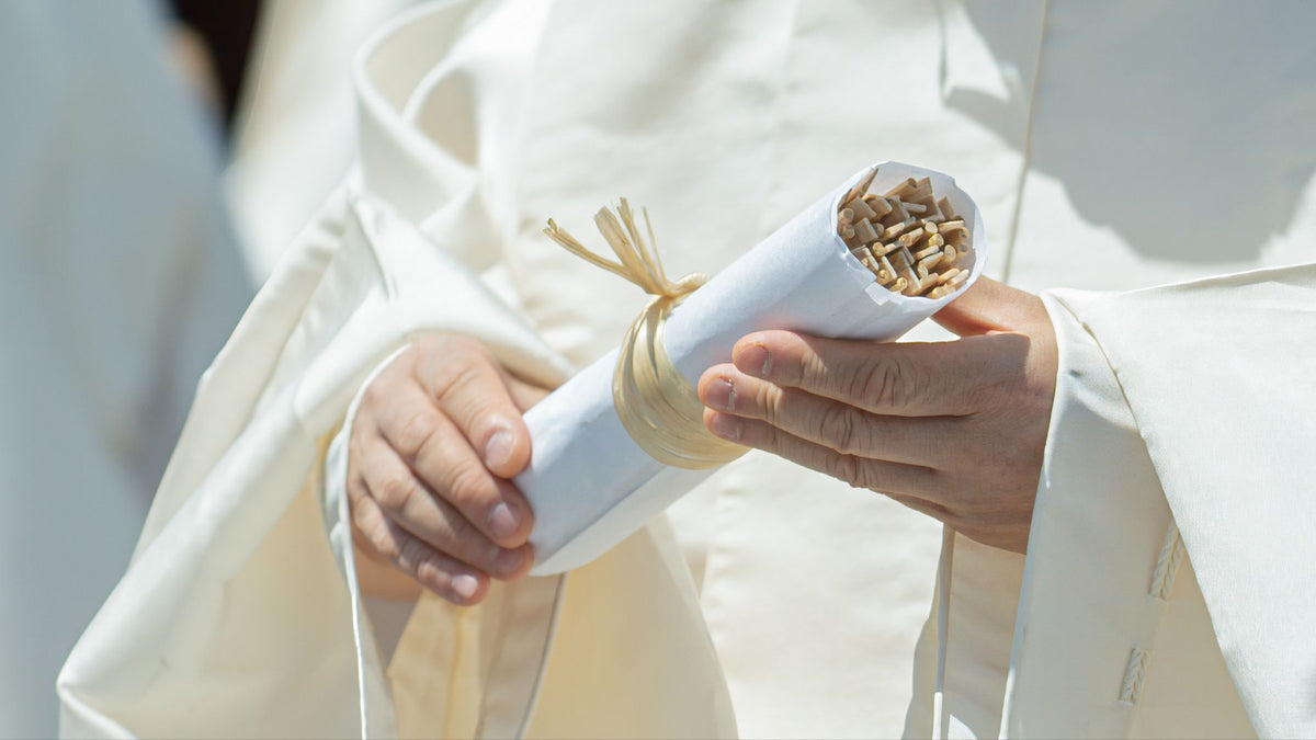 A Shinto priest holding chopsticks to be offered in a memorial service