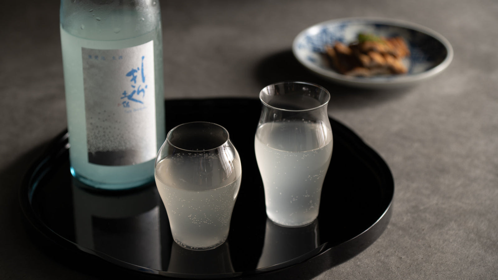 Chilled Japanese sake poured into a glass cup, capturing the refreshing character of natsuzake, summer sake.