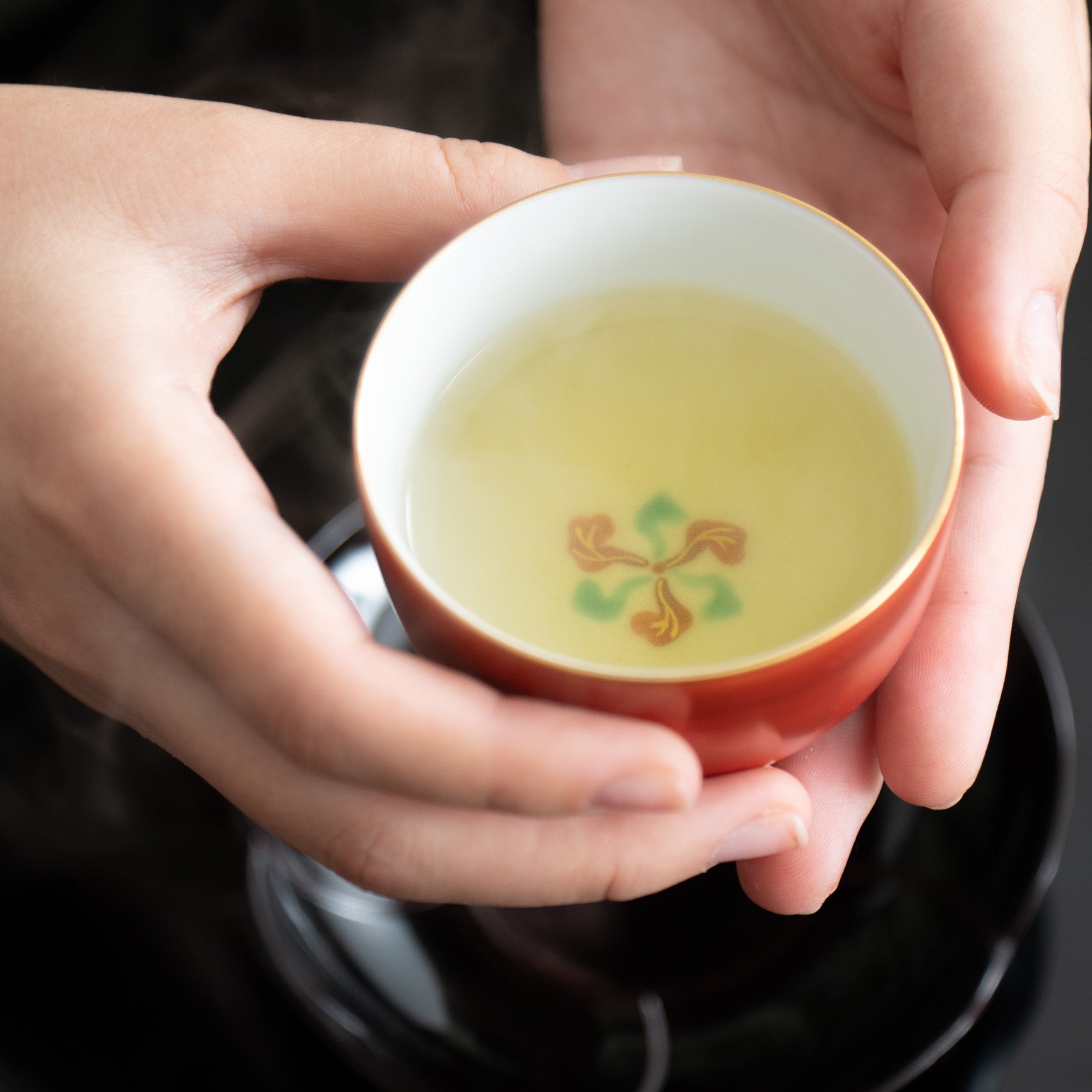 Taza de té japonesa roja con borde dorado