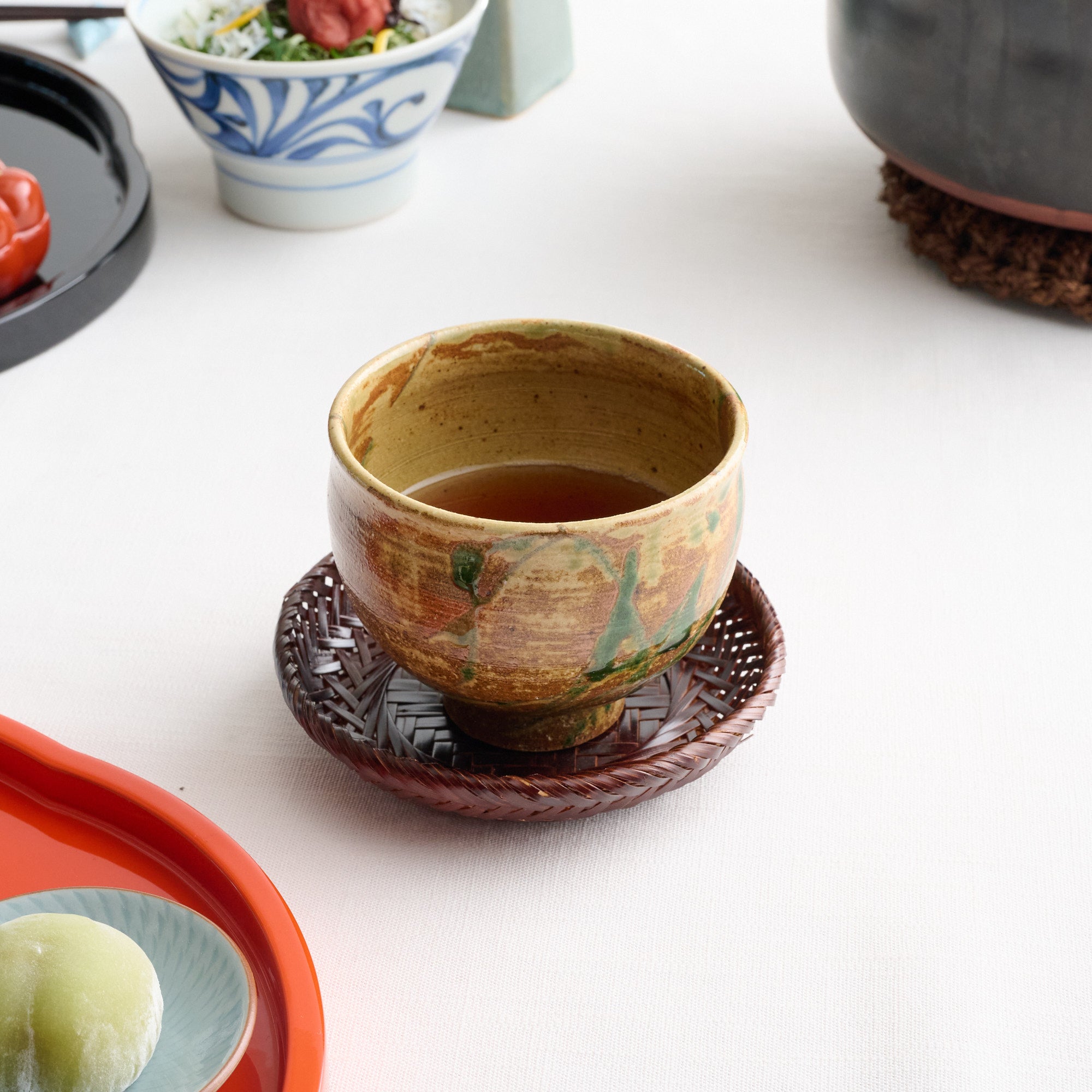 Taza de té japonesa con planta acuática marrón