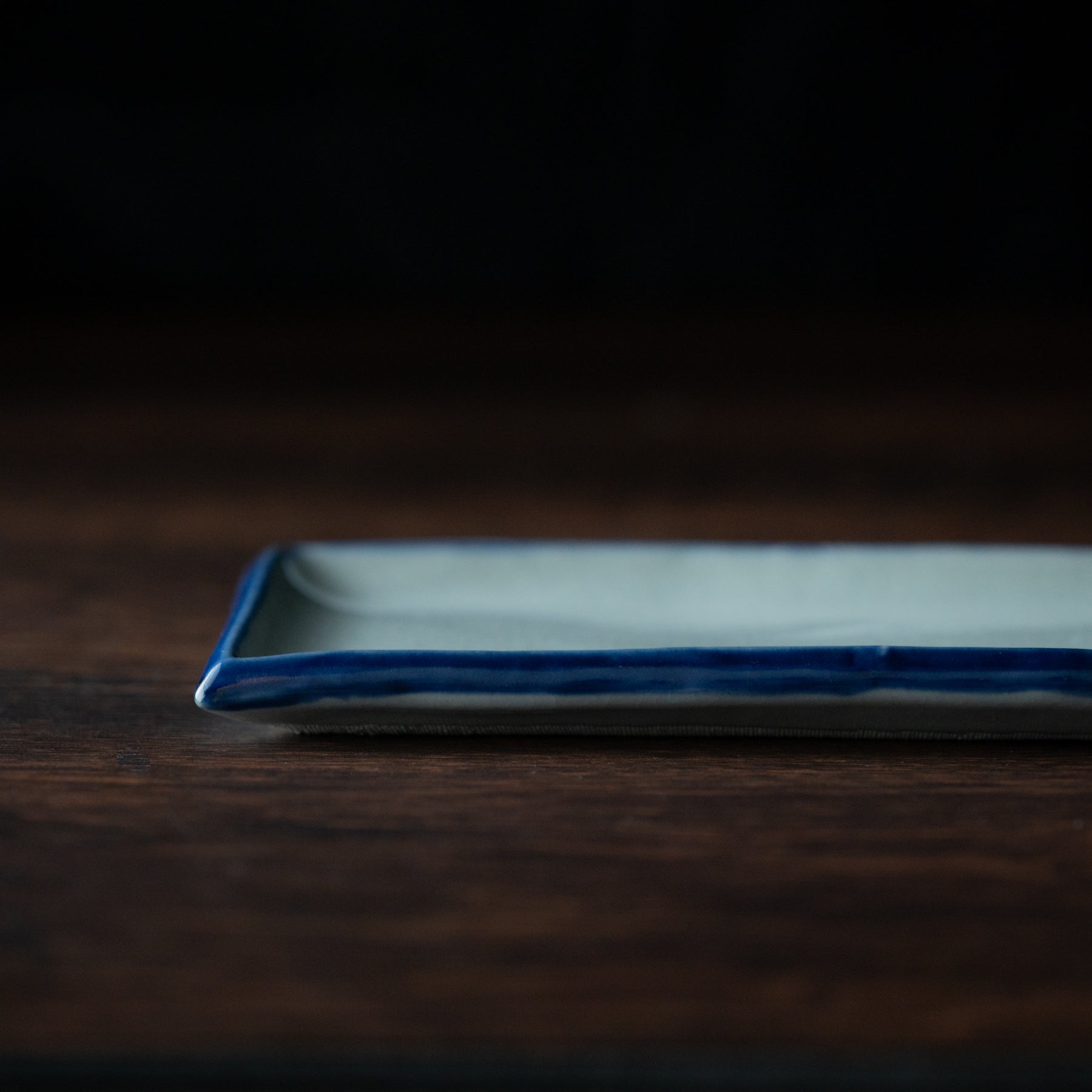 Rechteckiger Speiseteller mit blauem Pinselrand