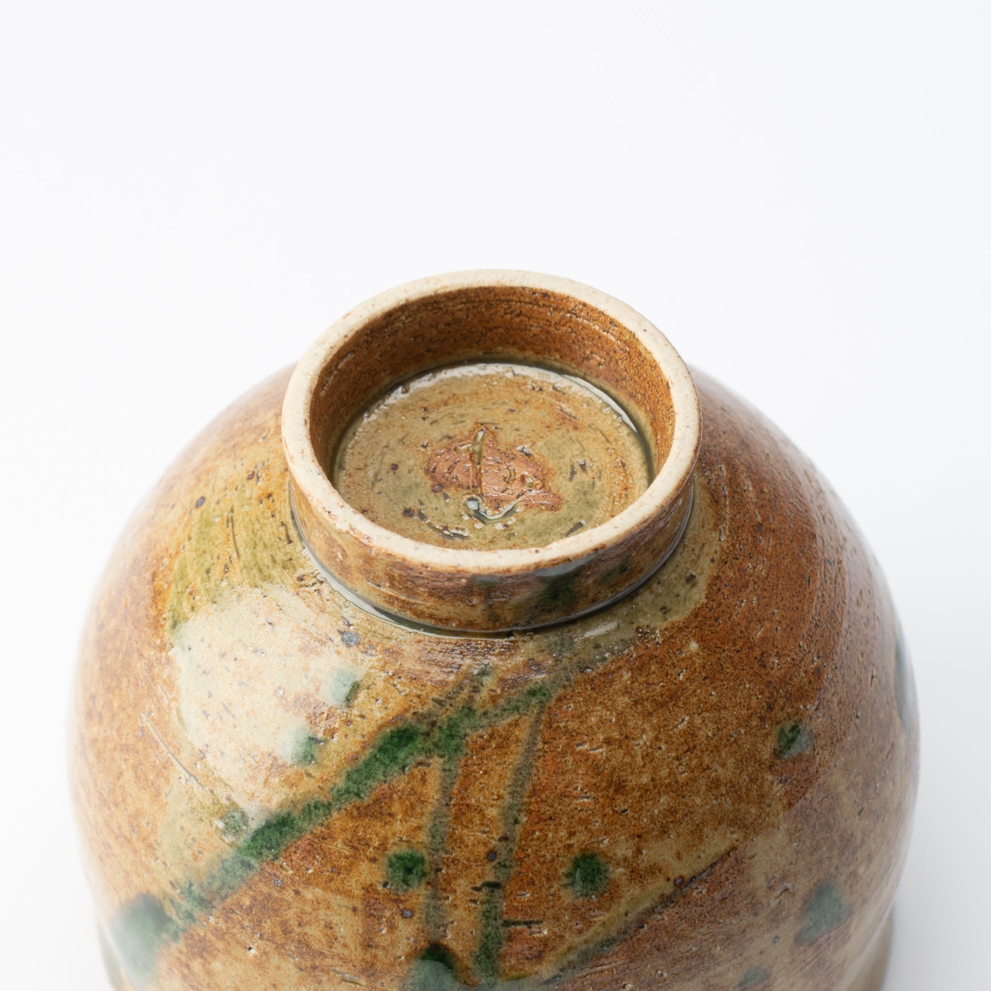 Taza de té japonesa con planta acuática marrón