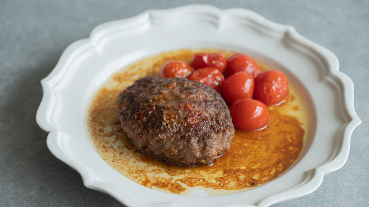 An appetizing hamburger steak served with cherry tomatoes