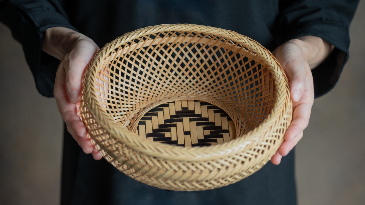 Hands holding a beautifully woven bamboo basket