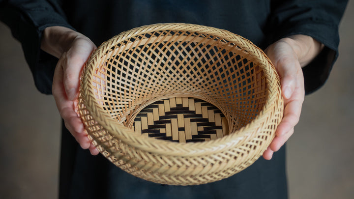 Hands holding a beautifully woven bamboo basket