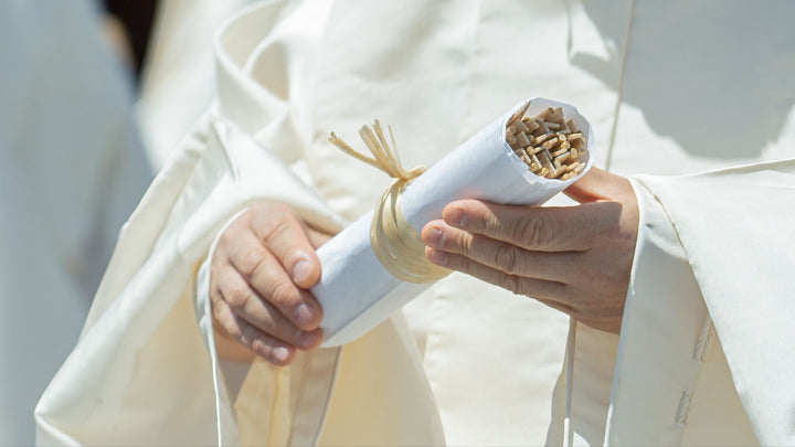 A Shinto priest holding chopsticks to be offered in a memorial service