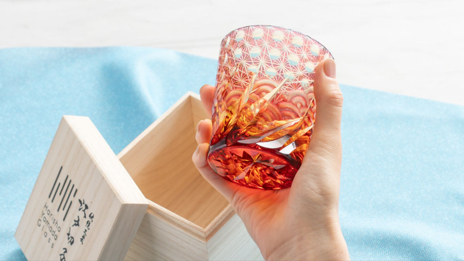 Hands holding a beautiful Edo Kiriko cut glass