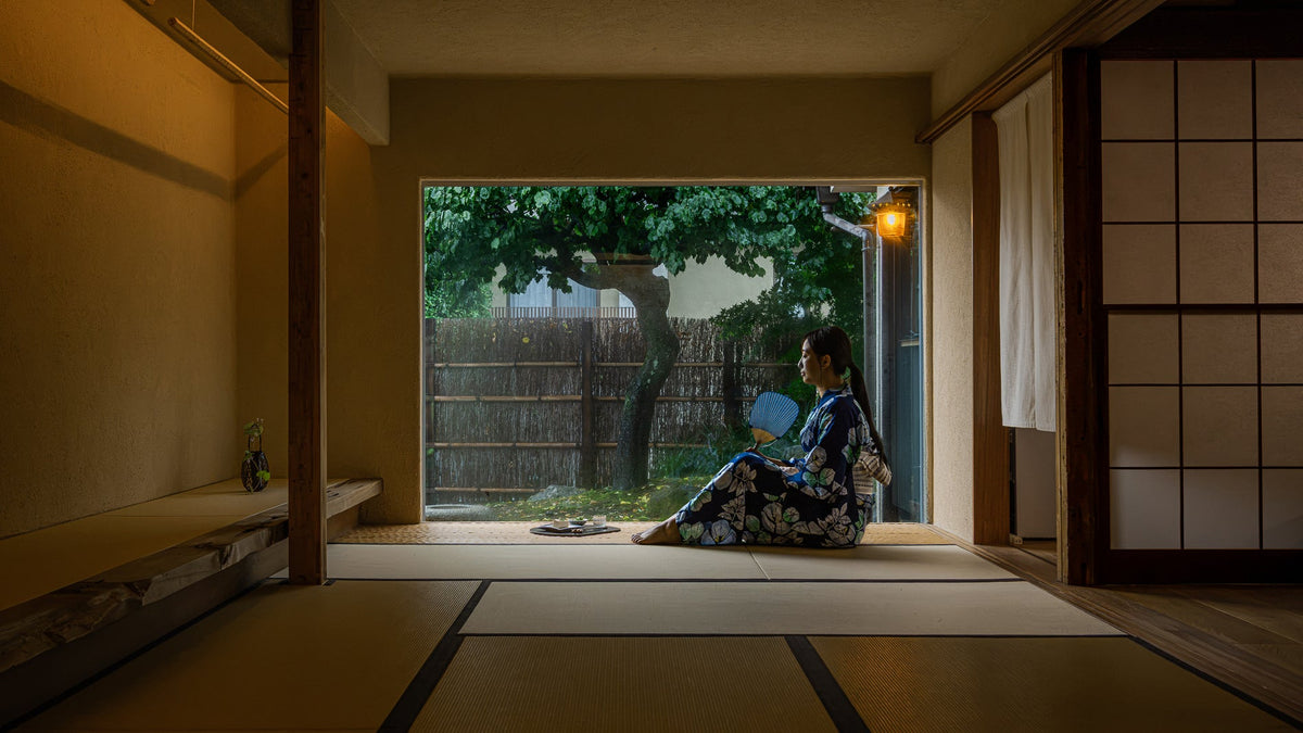 Woman relaxing in a Japanese tatami room during a cool summer evening (yusuzumi)