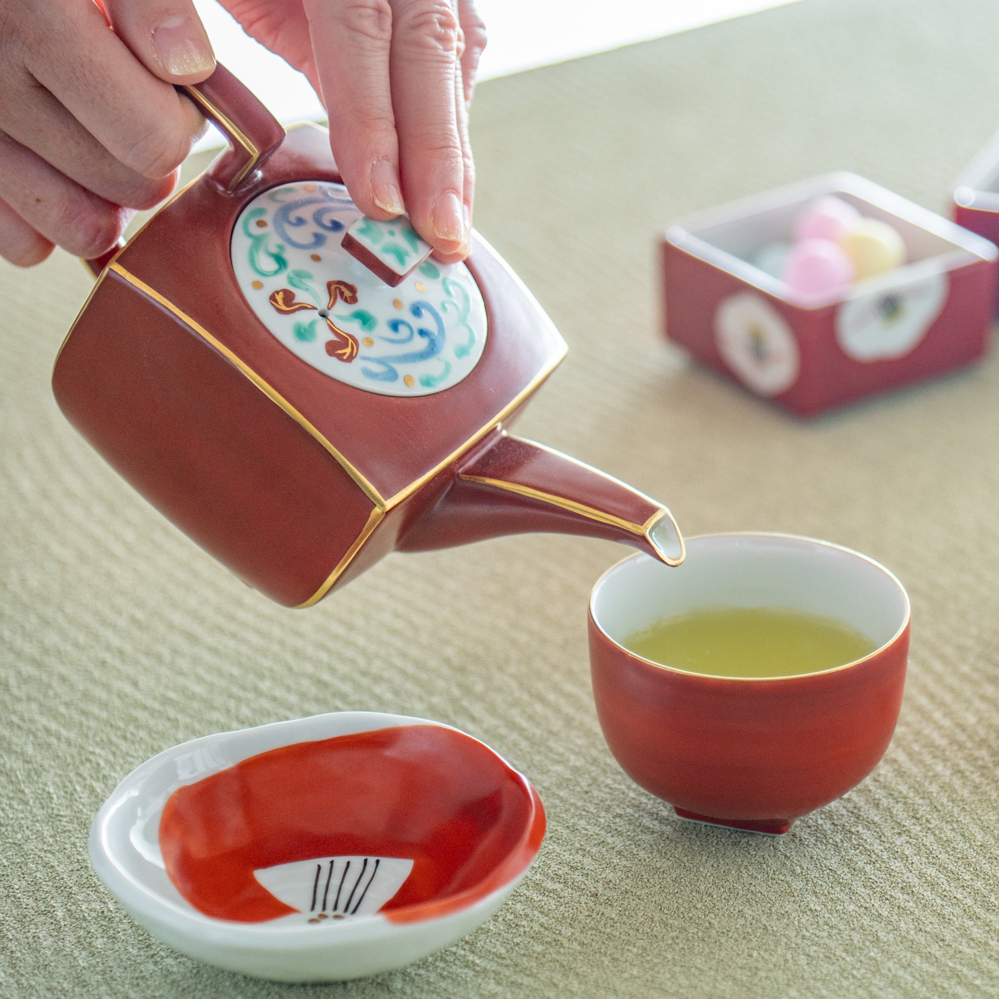 Taza de té japonesa roja con borde dorado