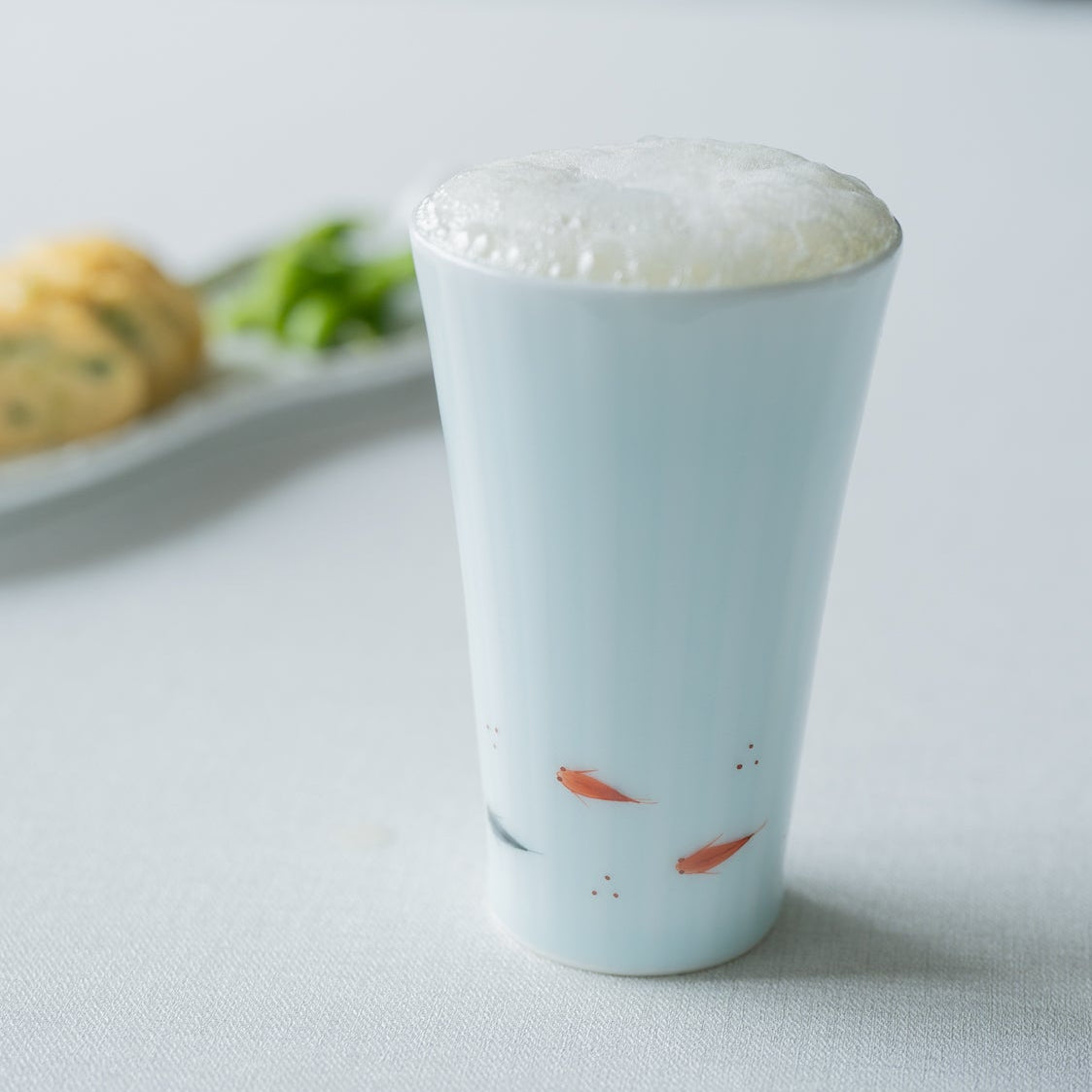 Copa de cerveza con pescado y arroz Medaka