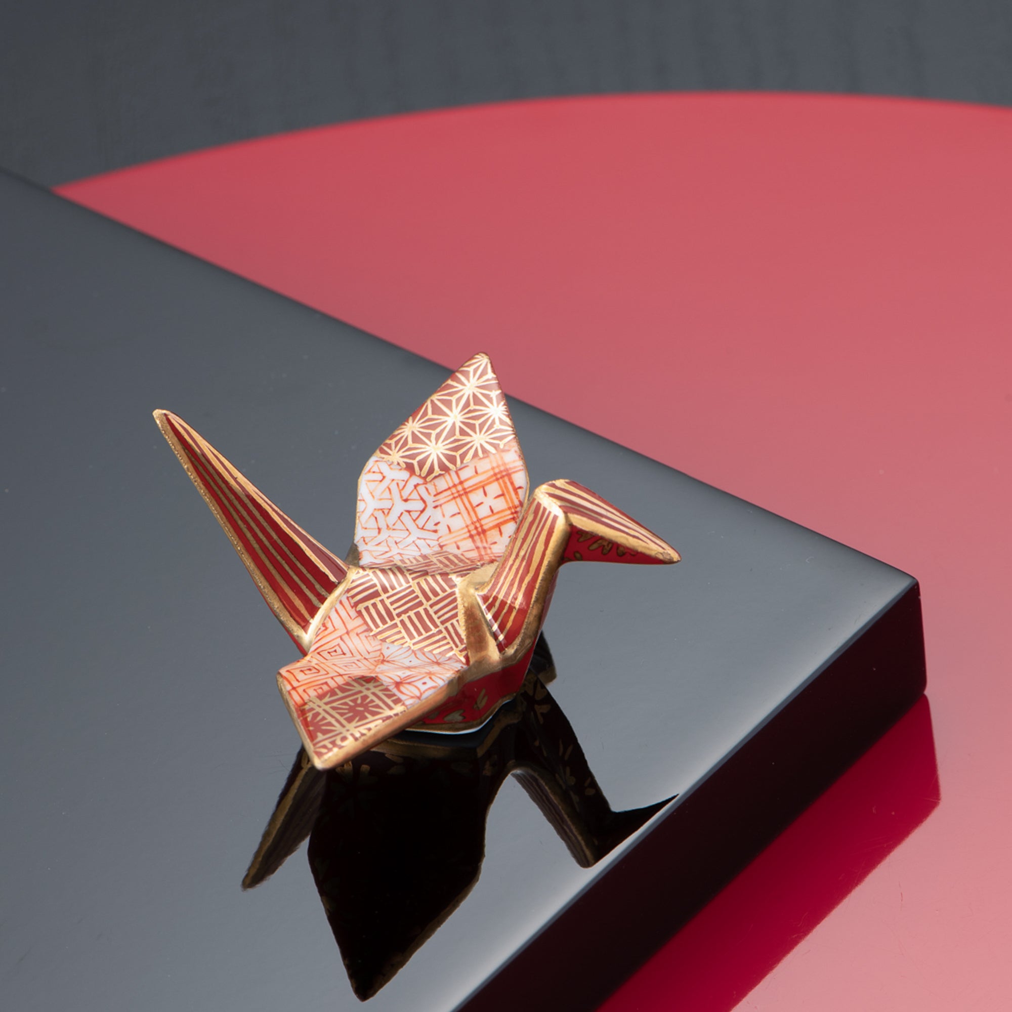 Adorno de Grulla con Patrones Geométricos Rojos